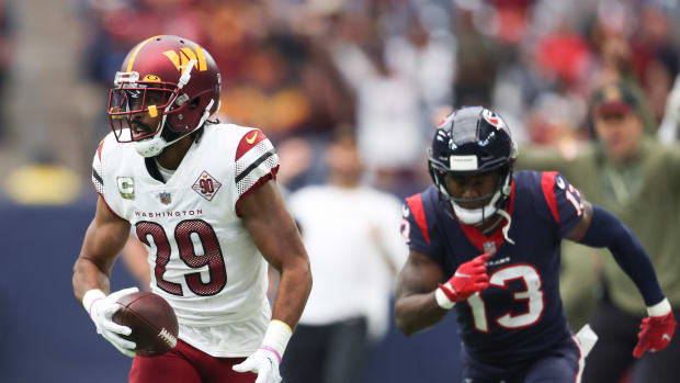 Washington Commanders cornerback Kendall Fuller (29) intercepts the ball against Houston Texans wide receiver Brandin Cooks (13) for a touchdown reception in the first quarter at NRG Stadium.
